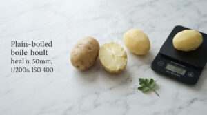 Three potatoes on a marble surface, one cut in half, with steam rising and a kitchen scale displaying weight.